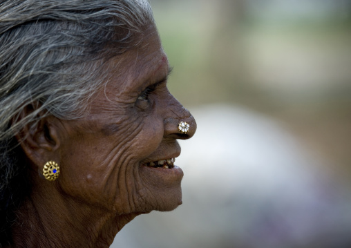 Side View Of An Old Indian Woman With Earrings And Nose Piercing And Blackish Teeth, Madurai, India