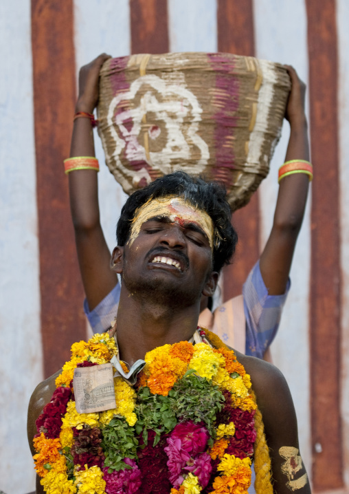 Suffering Man With Traditional Painting On His Forehead Followed By A Woman Carrying A Basket On Her Head During Fire Walking Ritual, Madurai, South India