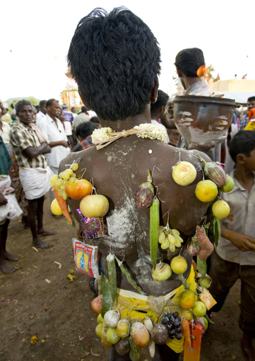 Rear View Of A Man With Various Offerings Hooked On His Back And Holding A Jar With Fire During Fire Walking Ritual, Madurai, South India