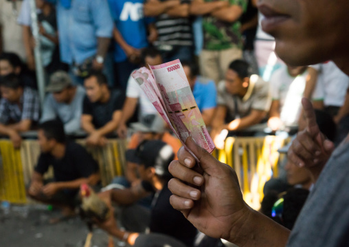 Men Taking The Money For The Bets During A Cockfigting Event