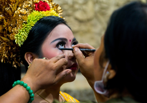 A Woman Applying Makeup To A Teenager Girl In Traditional  Costume Before A Tooth Filing Ceremony