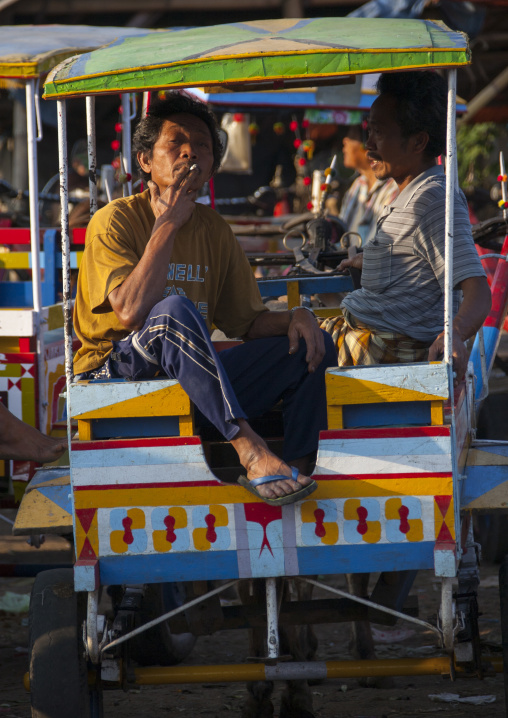 Portrait Of A Man Smoking A Cigarette, In A Rickshaw, Magbesik, Lombok Island, Indonesia