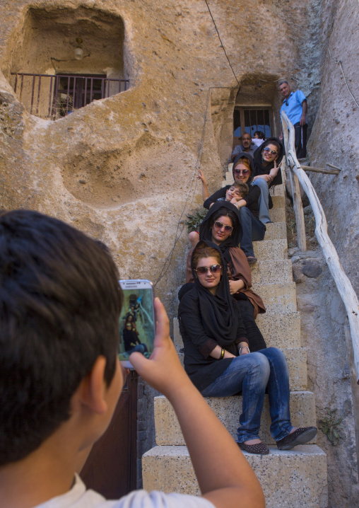 Tourists Taking Pictures In Front Of A Carved Home In The Village Of Kandovan, Iran