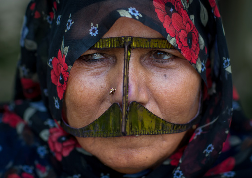 a bandari woman wearing a traditional mask called the burqa with a moustache shape, Qeshm Island, Salakh, Iran