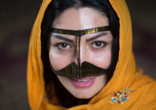 a smiling bandari woman wearing a traditional mask called the burqa with a moustache shape, Qeshm Island, Salakh, Iran