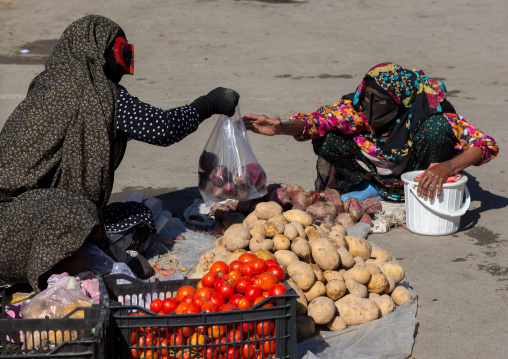 bandari women wearing the traditional masks called the burqas on a market, Hormozgan, Bandar Abbas, Iran
