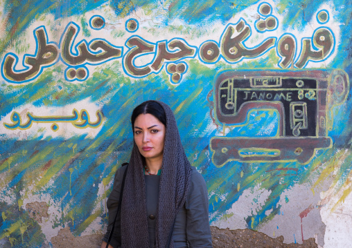 iranian woman posing in front of a tailor painted adverstising, Hormozgan, Bandar Abbas, Iran