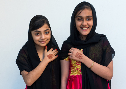 portrait of two young girls with henna tattooed hands in traditional bandari clothing during a wedding ceremony, Hormozgan, Bandar-e Kong, Iran