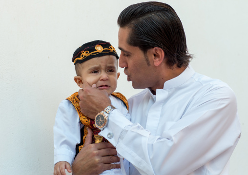 father with his crying son during a wedding ceremony, Hormozgan, Bandar-e Kong, Iran