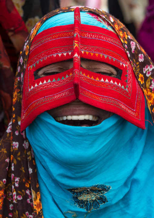 a laughing bandari woman wearing a traditional mask called the burqa at panjshambe bazar thursday market, Hormozgan, Minab, Iran