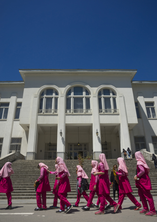 School girls passing in front of the white housein of iranian king at the saadabad palace, Shemiranat county, Tehran, Iran