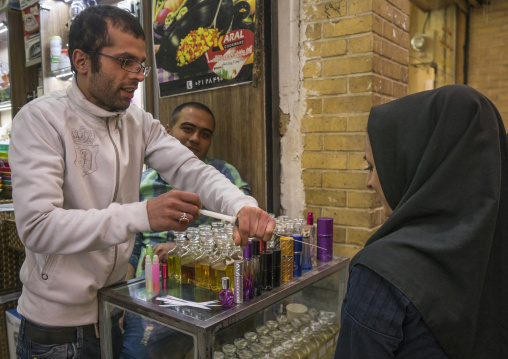 Man putting perfume on a woman with a syringe in tajrish bazaar, Shemiranat county, Tehran, Iran