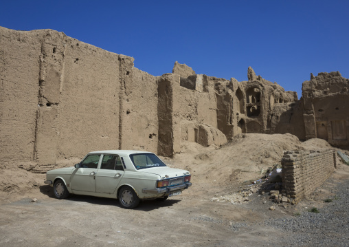 Car parked in front of old adobe houses, Isfahan province, Kashan, Iran