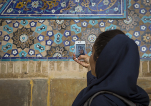 Iranian tourist taking picture with her mobile phone inside the friday mosque, Isfahan province, Isfahan, Iran