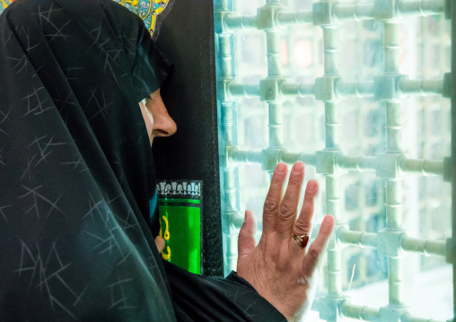 Woman in black chador praying in front of a shrine, Isfahan Province, Isfahan, Iran