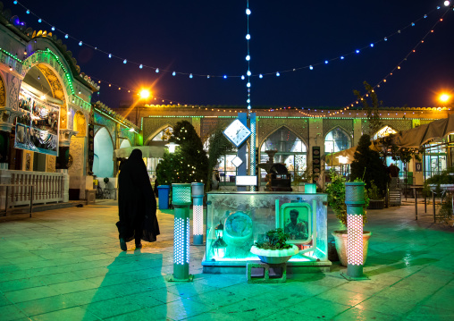 Iranian woman in chador going inside a mosque illuminated for Muharram to commemorate the martyrdom anniversary of Hussein, Isfahan Province, Isfahan, Iran