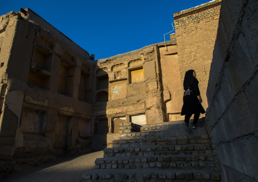One iranian girl walks in the the ruined houses of the old part of the town, Isfahan Province, Isfahan, Iran
