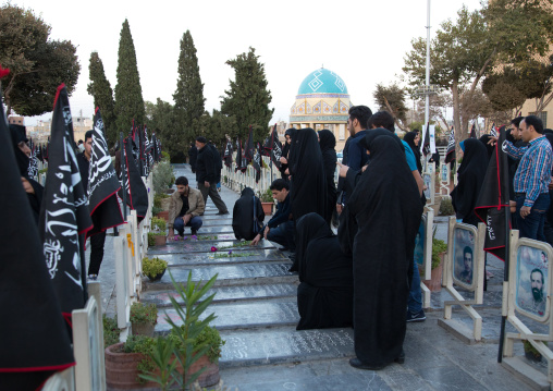 Families praying on the tomb of their sons killed in the Iran Iraq war in the Rose garden of martyrs cemetery, Isfahan Province, Isfahan, Iran