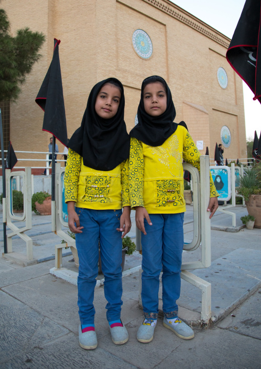 Portrait of iranian shiite twin girls in the rose garden of martyrs cemetery, Isfahan Province, Isfahan, Iran