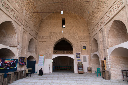 Iranian shiite man praying inside Jameh mosque, Isfahan Province, Ardestan, Iran