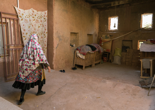 Iranian woman wearing traditional floreal chador in her house, Natanz County, Abyaneh, Iran