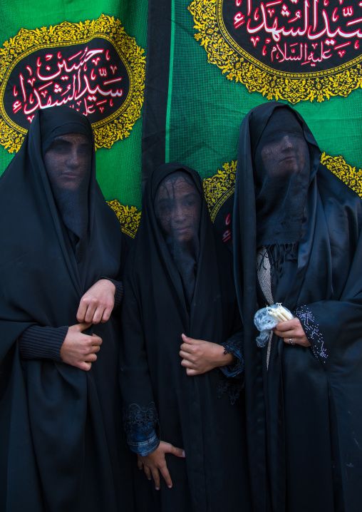 Portrait of iranian shiite muslim women with their faces hidden by a veil mourning Imam Hussein on Tasua during the Chehel Manbar ceremony one day before Ashura, Lorestan Province, Khorramaba