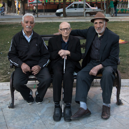 Old iranian men sit on a bench in a park, Lorestan Province, Khorramabad, Iran