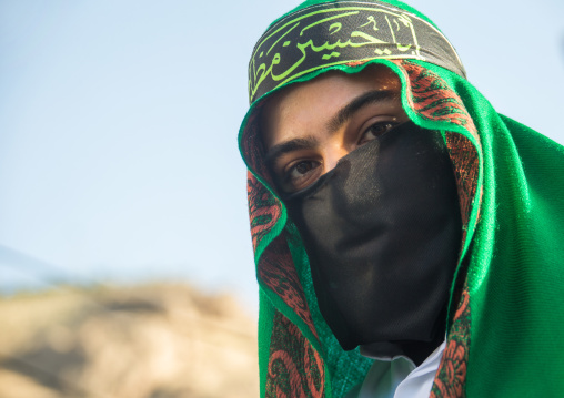 Iranian shiite muslim man with his face hidden by a veil mourning Imam Hussein on Tasua during the Chehel Manbar ceremony one day before Ashura, Lorestan Province, Khorramabad, Iran