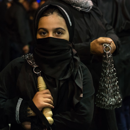 Iranian shiite muslim girl beating herself with iron chains during Muharram, Lorestan Province, Khorramabad, Iran