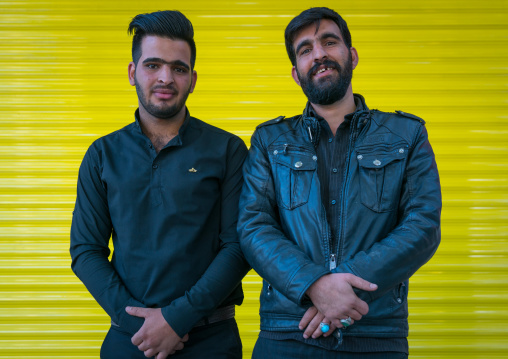 Iranian men in front of a yellow background, Lorestan Province, Khorramabad, Iran