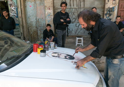 An artist paints the portrait of Abbas Bin Ali on a Peugeot car for Ashura celebrations to commemorate the martyrdom anniversary of Hussein, Lorestan Province, Khorramabad, Iran
