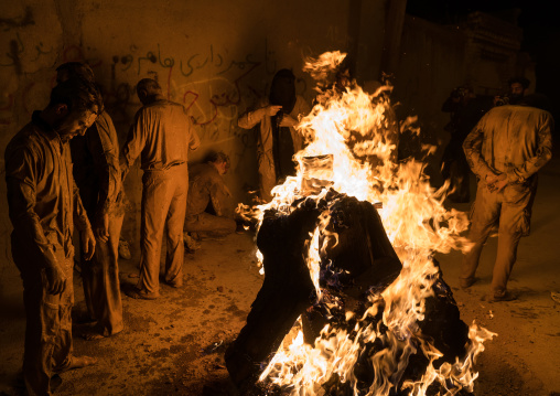 Iranian shiite muslim men gather around a bonfire after rubbing mud on their bodies during the Kharrah Mali ritual to mark the Ashura ceremony, Lorestan Province, Khorramabad, Iran