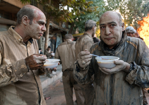 Iranian shiite muslim men eat their breakfasts after rubbing mud on their bodies early in the morning of Ashura day, Lorestan Province, Khorramabad, Iran
