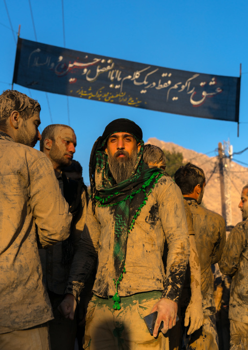 Iranian shiite muslim men gather around a bonfire after rubbing mud on their clothes during the Kharrah Mali ritual to mark the Ashura day, Lorestan Province, Khorramabad, Iran