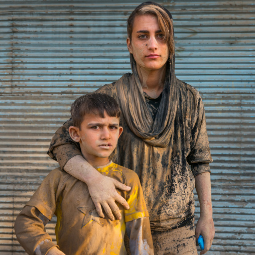 Portrait of iranian shiite brother and sister with mud stains on their clothes during the Ashura day, Lorestan Province, Khorramabad, Iran