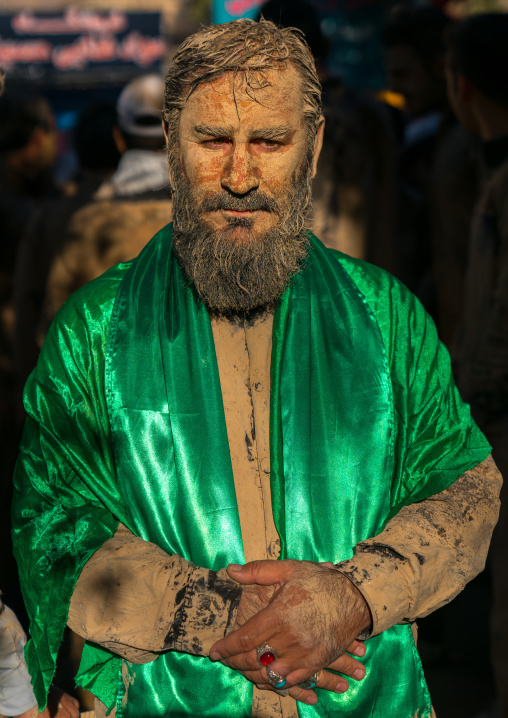 Iranian shiite muslim man with a green scarf after rubbing mud on his body during the Kharrah Mali ritual to mark the Ashura ceremony, Lorestan Province, Khorramabad, Iran
