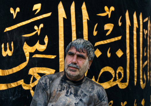 Iranian shiite muslim man after rubbing mud on his body during the Kharrah Mali mud bath ritual to mark the Ashura ceremony, Lorestan Province, Khorramabad, Iran