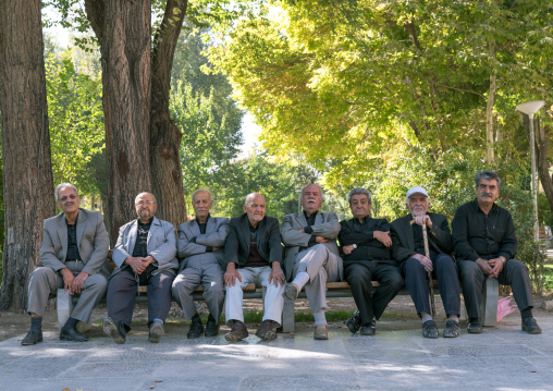 Old iranian men sit on a bench in Chehel Sotoun gardens, Isfahan Province, Isfahan, Iran