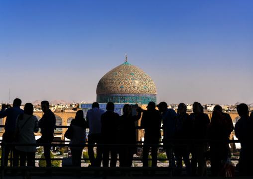 Silhouettes of tourists looking at Sheikh Lutfollah Mosque standing on the eastern side of Naghsh-i Jahan Square, Isfahan Province, Isfahan, Iran