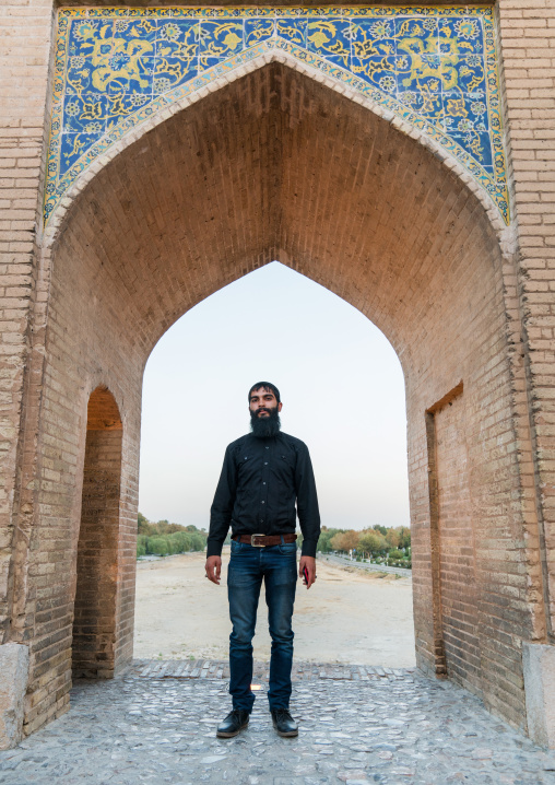Man with a beard standing on Khaju bridge Pol-e Khaju over dry Zayandeh river, Isfahan Province, Isfahan, Iran