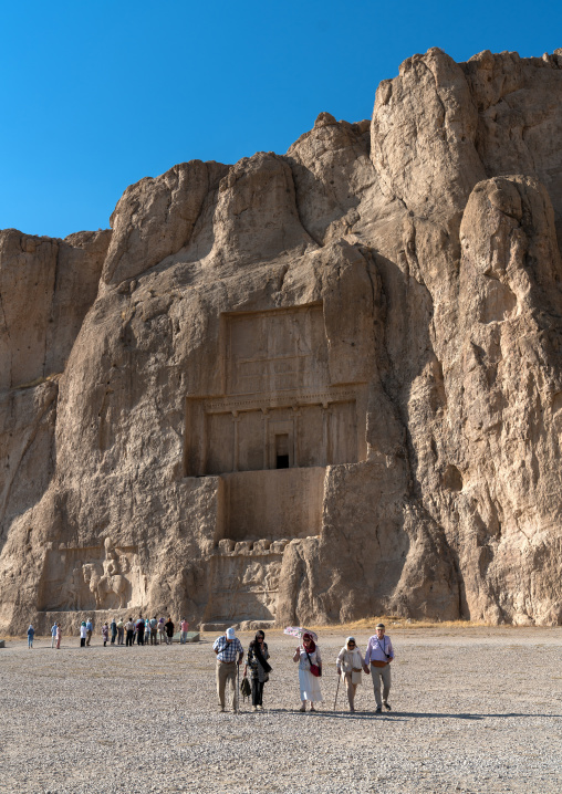 Tourists visting the achaemenian royal tombs in Naqsh-e Rustam necropolis, Fars Province, Shiraz, Iran