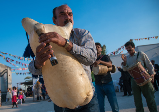 men dancing and playing sheep skin pipe bag during a wedding ceremony, Hormozgan, Kushkenar, Iran