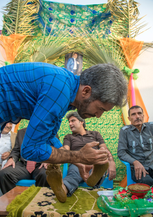 groom being covered with henna during his wedding ceremony, Hormozgan, Kushkenar, Iran
