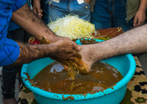 groom feet being covered with henna during his wedding ceremony, Hormozgan, Kushkenar, Iran