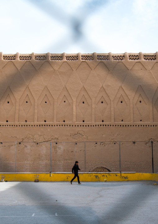 boy playing football in front of the old rampart, Central County, Kerman, Iran