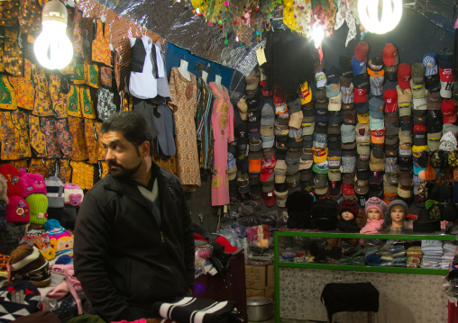 man selling american caps and traditional embroidered trousers in ganjali bazaar, Central County, Kerman, Iran