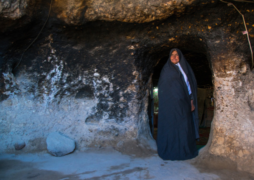 old widow woman at the entrance of her troglodyte house, Kerman province, Meymand, Iran