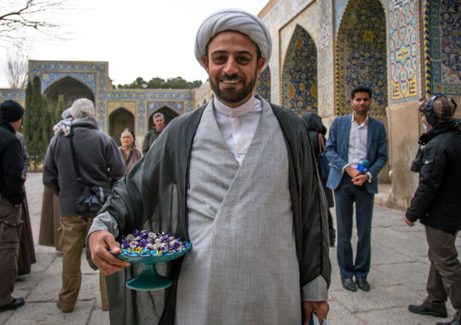 mullah giving sweets to tourists visiting friday mosque for pr operation filmed by iranian television, Isfahan Province, isfahan, Iran