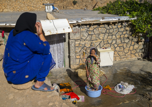 Women Washing Clothes In The Old Kurdish Village Of Palangan At Dusk, Iran
