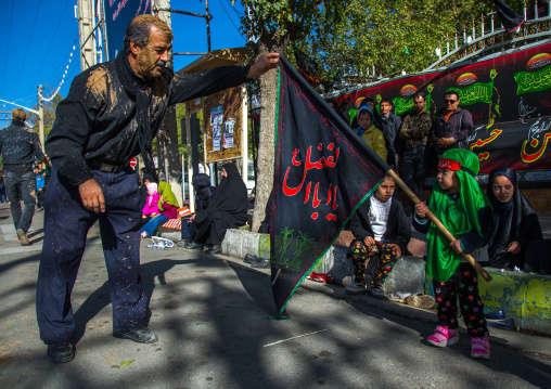 Iranian Shiite Man Raising A Flag Hold By A Girl On Ashura, The Day Of The Death Of Imam Hussein, Kurdistan Province, Bijar, Iran